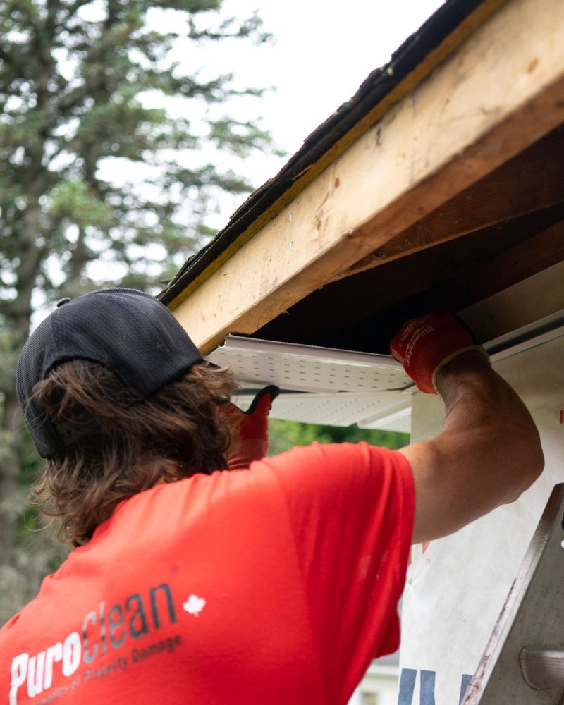 SoffitPro technician installing seamless aluminum gutters in Tampa, FL